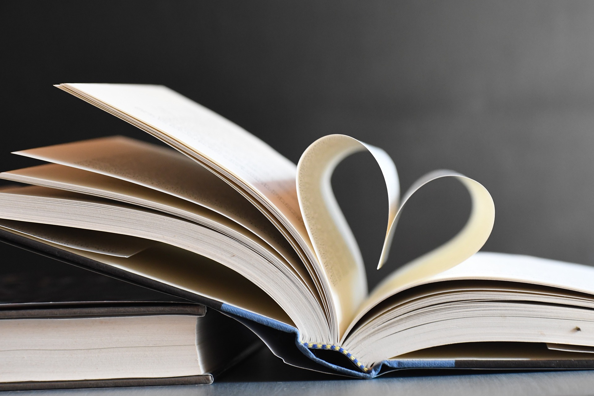 En öppen bok där bokbladen formar ett hjärta
