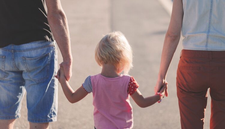 Två vuxna som håller ett barn i handen Familjehem Lex Lilla HJärtat