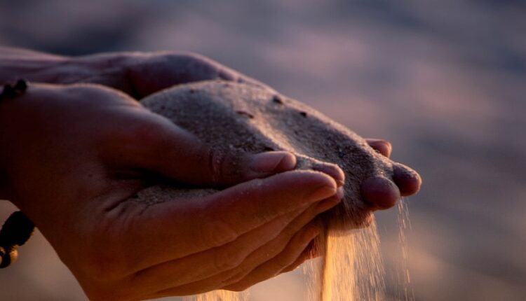 Sand som rinner mellan fingrarna